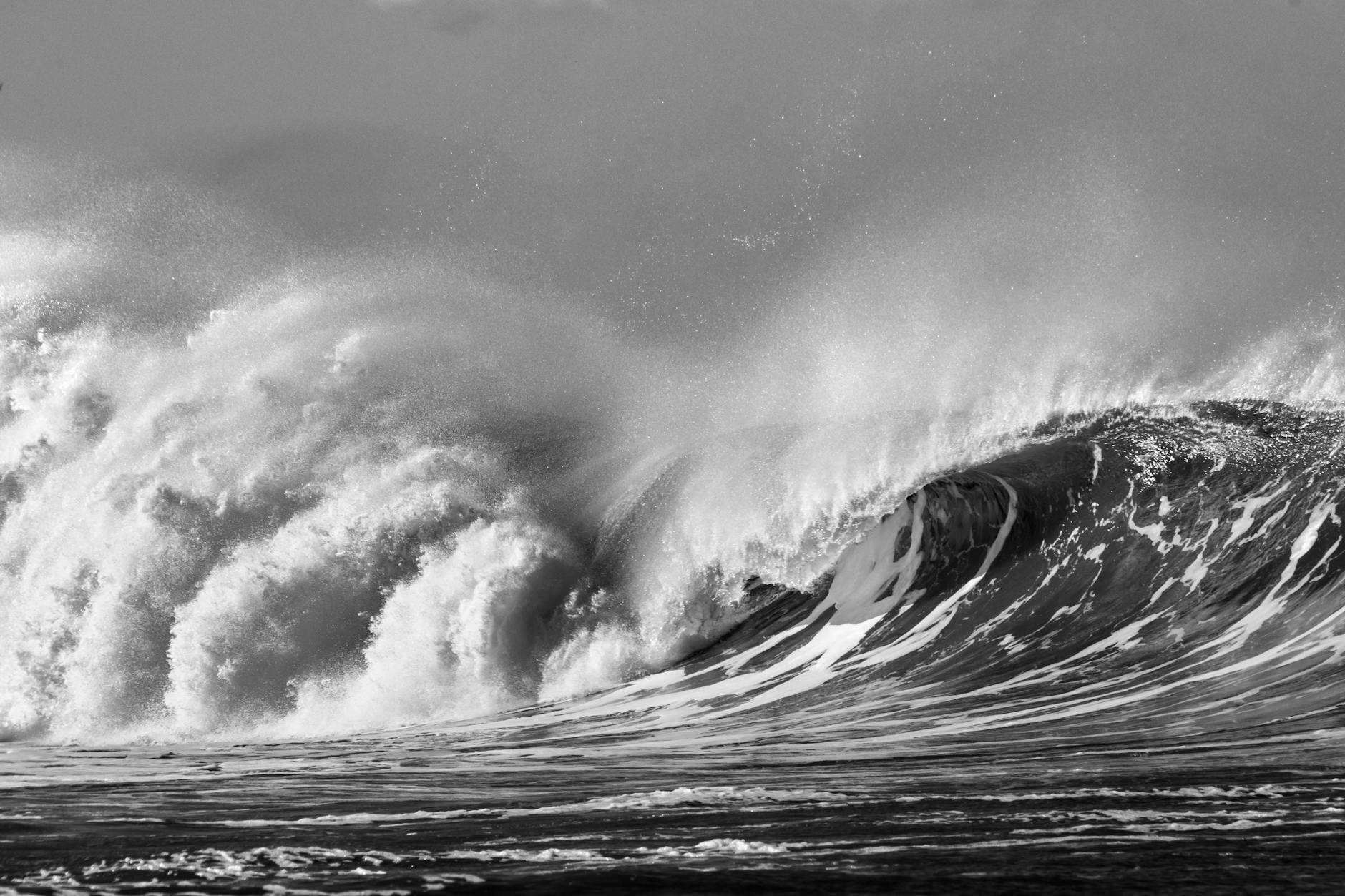 a grayscale photo of big ocean waves